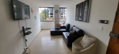 a living room with a couch and a tv at 1023 Los Colores Estadio apartamento - Parqueadero - Zona Wifi - Coworking - Área exclusiva de la ciudad in Medellín