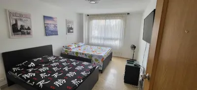 a small bedroom with two beds and a television at 1023 Los Colores Estadio apartamento - Parqueadero - Zona Wifi - Coworking - Área exclusiva de la ciudad in Medellín