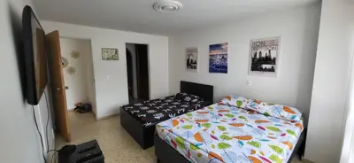 a bedroom with a bed and a television in it at 1023 Los Colores Estadio apartamento - Parqueadero - Zona Wifi - Coworking - Área exclusiva de la ciudad in Medellín