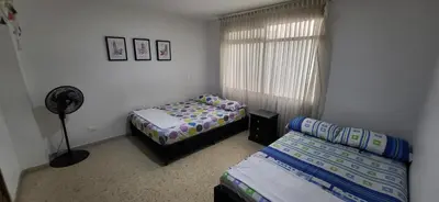 a bedroom with two beds and a fan and a window at 1023 Los Colores Estadio apartamento - Parqueadero - Zona Wifi - Coworking - Área exclusiva de la ciudad in Medellín