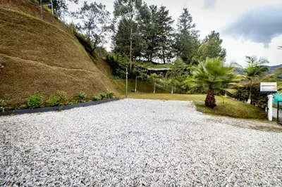 a gravel driveway in front of a hill at Finca-Hotel Montecarlo Guatape by Hope in Guatapé