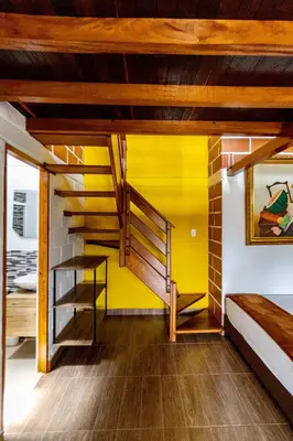 a room with a yellow wall and stairs at Finca-Hotel Montecarlo Guatape by Hope in Guatapé