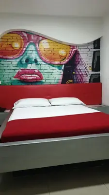 a bedroom with a mural of a woman with glasses at Kromatic Hostel in Medellín