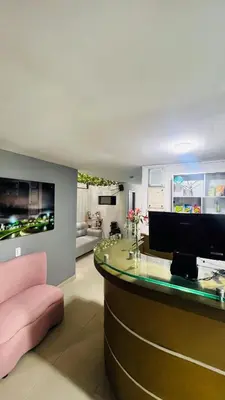 a living room with a bar with a pink chair at Kromatic Hostel in Medellín