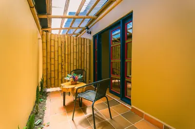a balcony with a table and chairs and a window at Hotel Bambu Guatape in Guatapé