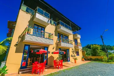 a building with red chairs in front of it at Hotel Bambu Guatape in Guatapé