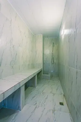 a room with a bench in a room with marble walls at Hotel Bambu Guatape in Guatapé