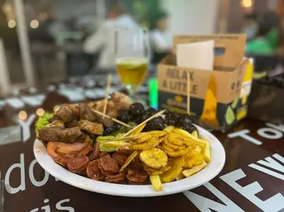 a plate of food on a table with a glass of beer at New Lovely 3 bedroom condo with an AWESOME view! in Bello