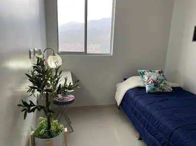 a bedroom with a blue bed and a potted plant at New Lovely 3 bedroom condo with an AWESOME view! in Bello