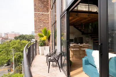a balcony with a blue couch and chairs at Royal Living Poblado in Medellín