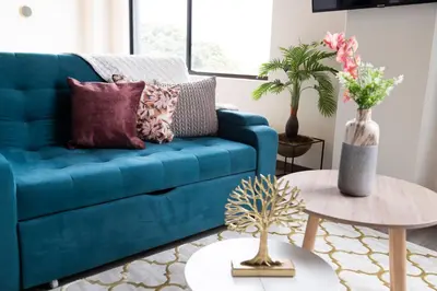 a blue couch in a living room with a table at Royal Living Poblado in Medellín