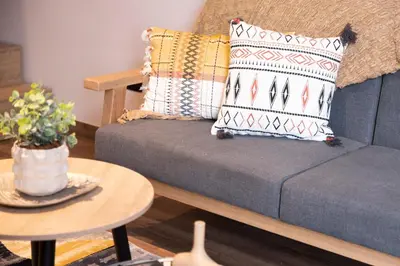 a living room with a couch with pillows and a table at Royal Living Poblado in Medellín
