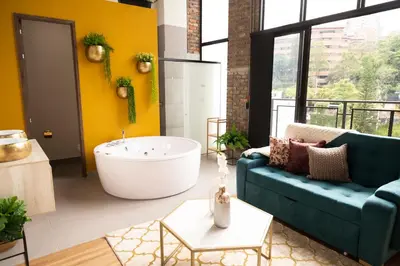 a living room with a tub and a blue couch at Royal Living Poblado in Medellín