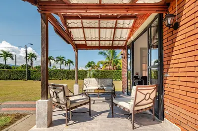 a patio with two chairs and a table and a building at Moderna cabaña en Viterbo con Aire AC y Piscina in Viterbo