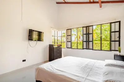 a white bedroom with a bed and windows at Moderna cabaña en Viterbo con Aire AC y Piscina in Viterbo