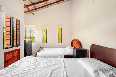two beds in a room with white walls and windows at Moderna cabaña en Viterbo con Aire AC y Piscina in Viterbo