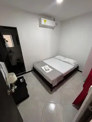 a small bedroom with a bed and a window at Hotel SG in Doradal