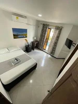 a bedroom with a bed and a television in it at Hotel SG in Doradal