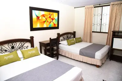 a hotel room with two beds and a television at Ayenda 1133 Casa Polty in Manizales