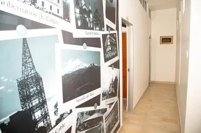 a hallway with a wall with pictures offamous cities at Ayenda 1133 Casa Polty in Manizales