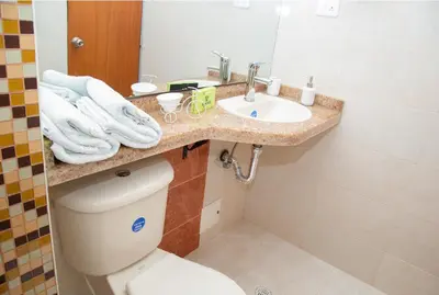 a bathroom with a toilet and a sink with towels at Ayenda 1133 Casa Polty in Manizales