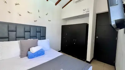 a bedroom with a bed with a black headboard at Hermoso Apartasol!! cerca a Plaza Principal, Aire Acondicionado, Vista a la Piscina in Santa Fe de Antioquia