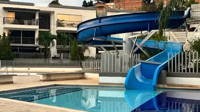 a blue water slide in a swimming pool at Hermoso Apartasol!! cerca a Plaza Principal, Aire Acondicionado, Vista a la Piscina in Santa Fe de Antioquia