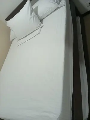 a white bed with two pillows on top of it at Hermoso Apartasol!! cerca a Plaza Principal, Aire Acondicionado, Vista a la Piscina in Santa Fe de Antioquia