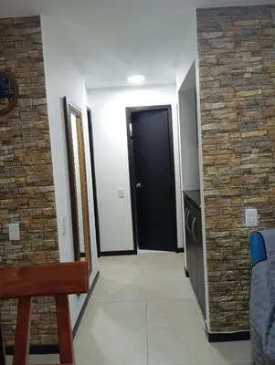 a hallway with a black door and a brick wall at Hermoso Apartasol!! cerca a Plaza Principal, Aire Acondicionado, Vista a la Piscina in Santa Fe de Antioquia