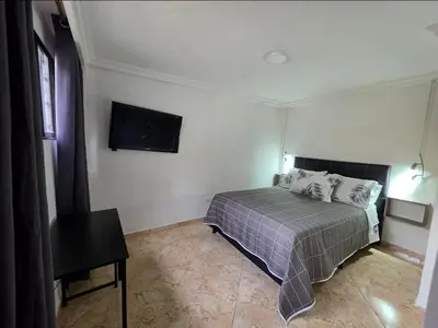 a bedroom with a bed and a flat screen tv at alojamiento entero a 800metros estación poblado in Medellín
