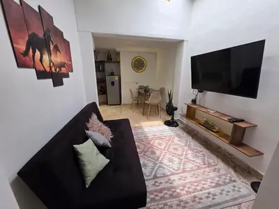 a living room with a couch and a flat screen tv at alojamiento entero a 800metros estación poblado in Medellín