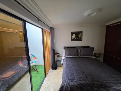 a bedroom with a bed and a sliding glass door at alojamiento entero a 800metros estación poblado in Medellín