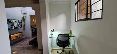 a glass desk with a chair in a room at alojamiento entero a 800metros estación poblado in Medellín