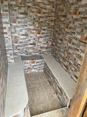 a sauna with a brick wall and two benches at Finca Santa Monica Guatape in Guatapé