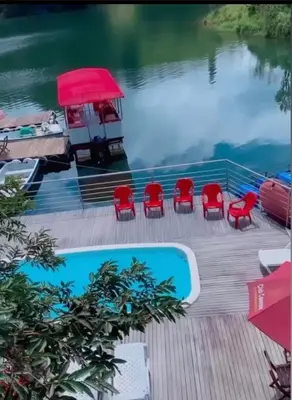 a deck with red chairs and a swimming pool at Finca Santa Monica Guatape in Guatapé
