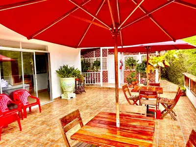 a red umbrella on a patio with a table and chairs at Finca Santa Monica Guatape in Guatapé