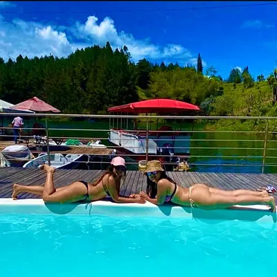 two women laying in the water in a swimming pool at Finca Santa Monica Guatape in Guatapé