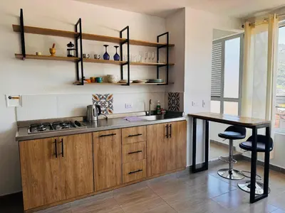 a kitchen with wooden cabinets and a wooden table at Lagom Apartamentos San Rafael in San Rafael