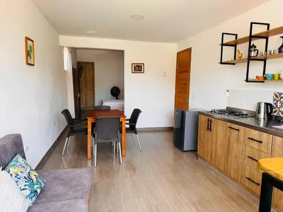 a kitchen and living room with a table and chairs at Lagom Apartamentos San Rafael in San Rafael