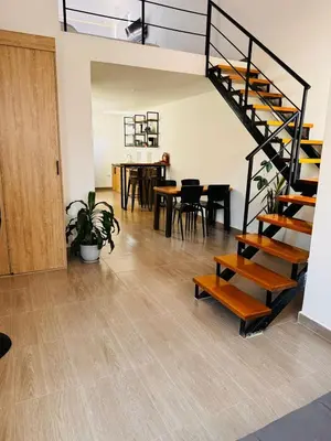 a room with a staircase and a table and chairs at Lagom Apartamentos San Rafael in San Rafael