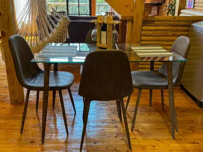 a glass table with four chairs in a room at Cabaña con Jacuzzi en Santa Elena in Medellín