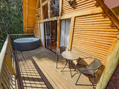 a deck with a table and chairs and a tub at Cabaña con Jacuzzi en Santa Elena in Medellín