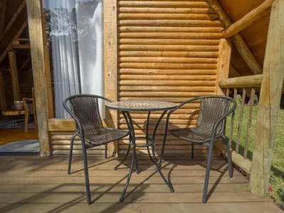 two chairs and a table on a porch at Cabaña con Jacuzzi en Santa Elena in Medellín