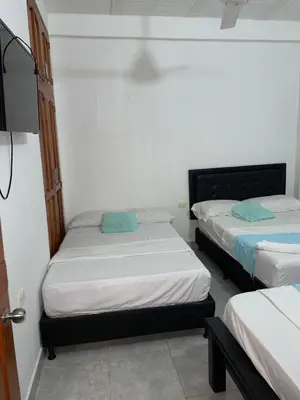 a room with two beds and a flat screen tv at casa amoblada, Doradal Antioquia, Santorini colombiano in Doradal