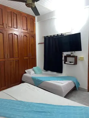 a bedroom with two beds and a flat screen tv at casa amoblada, Doradal Antioquia, Santorini colombiano in Doradal