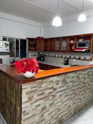 a kitchen with a counter with red flowers on it at casa amoblada, Doradal Antioquia, Santorini colombiano in Doradal