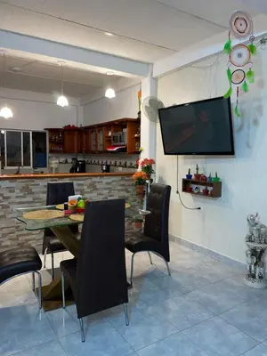a dining room with a table and chairs and a tv at casa amoblada, Doradal Antioquia, Santorini colombiano in Doradal