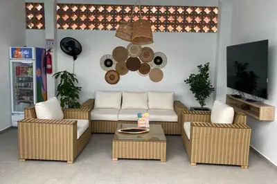 a living room with a couch and chairs and a tv at Hotel Medallo City in Medellín