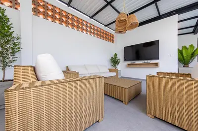 a living room with wicker furniture and a tv at Hotel Medallo City in Medellín