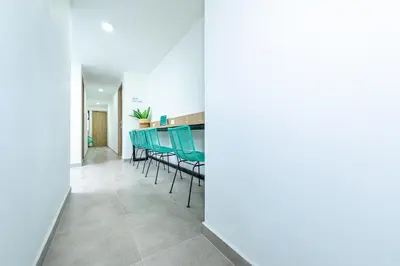 a dining room with green chairs and a table at Hotel Medallo City in Medellín